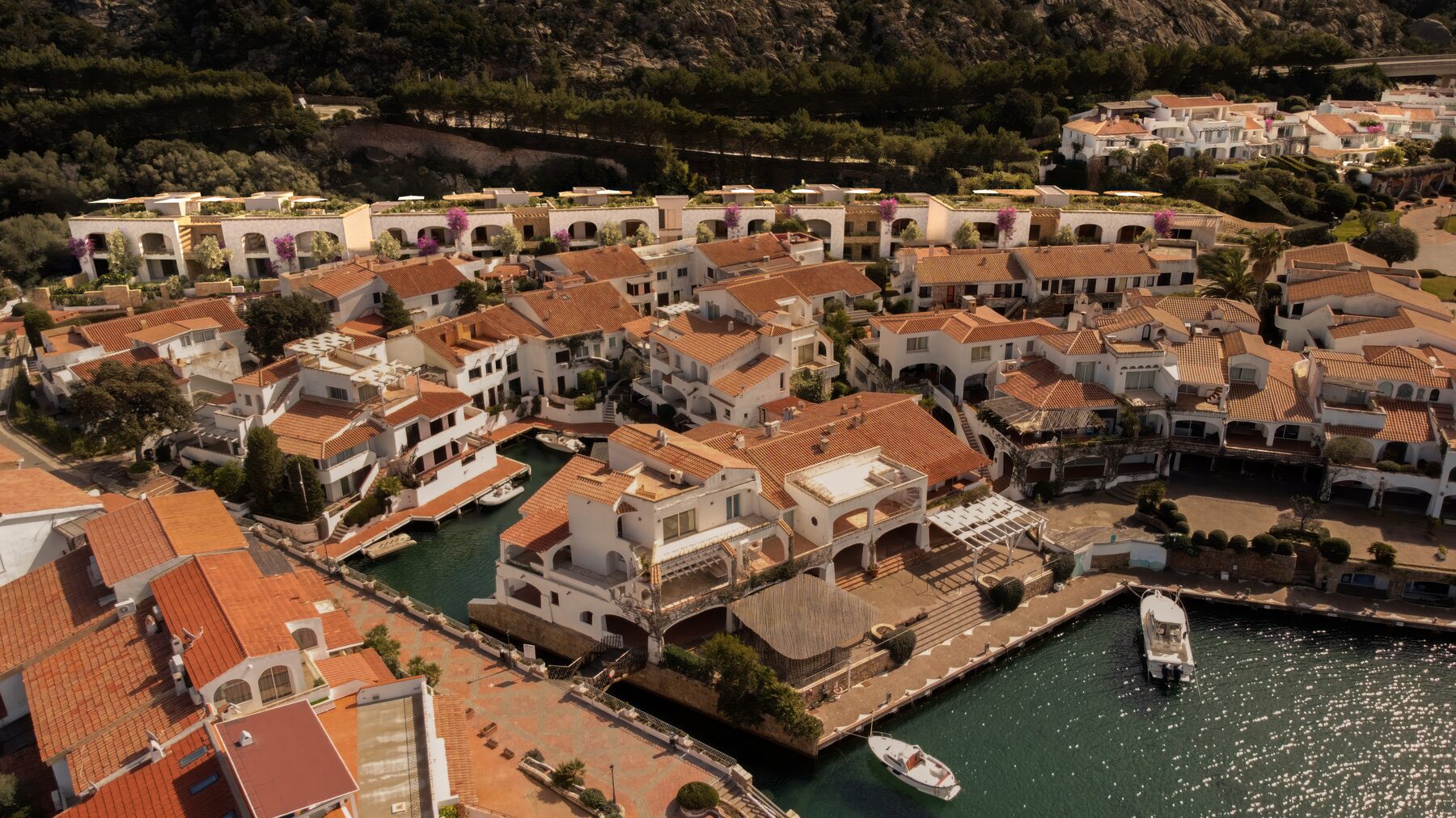 Veduta aerea del borgo di Poltu Quatu tra la macchia mediterranea e la darsena